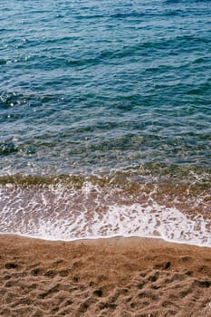 Sea waves roll on the sandy shore. High quality photo