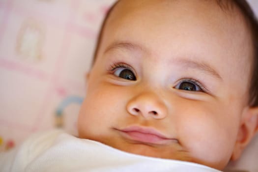 Smile, portrait and a baby on a bed for playing, wake up and cozy in the morning. Happy, youth and face of a girl, infant kid or child in the bedroom of a house to relax with comfot in childhood.