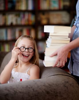 Smile, stack of books and kid in library, learning and relax, studying homework knowledge on couch. School, woman and girl child with glasses in bookstore together with story, and education on sofa