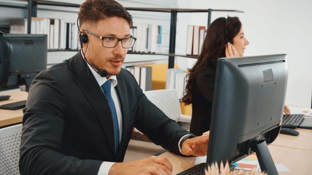 Business people wearing headset working in office to support remote customer or colleague. Call center, telemarketing, customer support agent provide service on telephone video conference call. Jivy