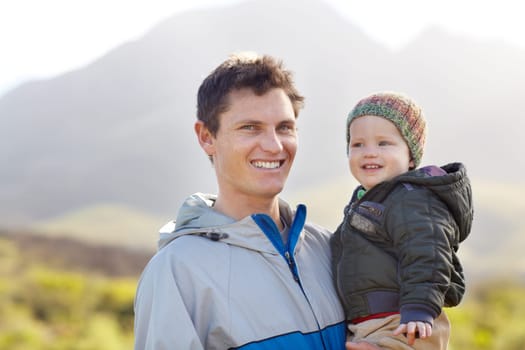 Portrait, father and child for hiking in mountains for wellness, travel or fun. Sweden, man and baby for smile, happy or excited in quality time, together and fresh air on trip for love, care or bond.