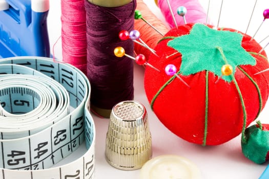 Some sewing supplies with pin, tape and meter