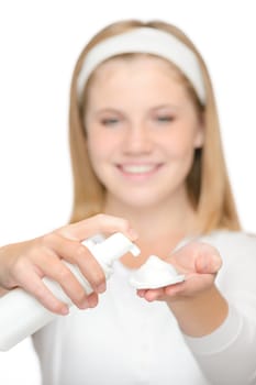 Cheerful teenager girl using cleaning foam cream moisturizer