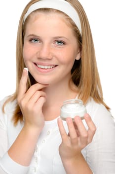 Cheerful young girl applying moisturizer face cream fingers