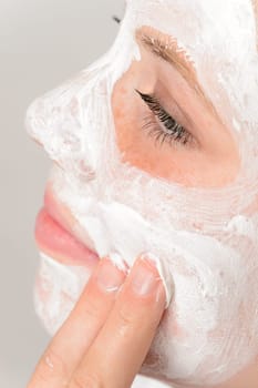 Fingers applying face mask moisturizer cream young girl beauty treatment