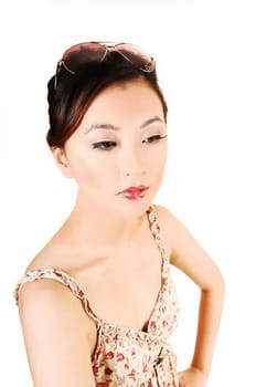 A closeup portrait of a beautiful chinese woman with sunglasses on her head and a light summer dress for white background.
