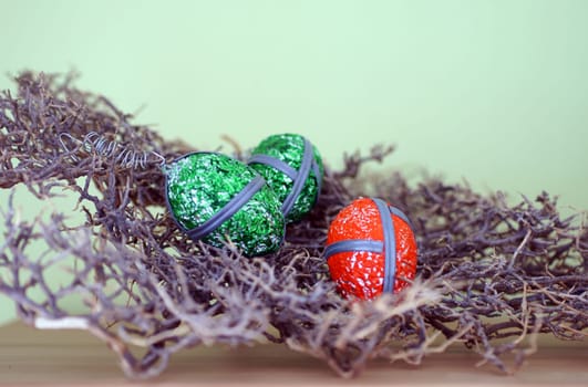 Die Makro Nahaufnahme markanter Ostereier in einem Zweiggeflecht.
