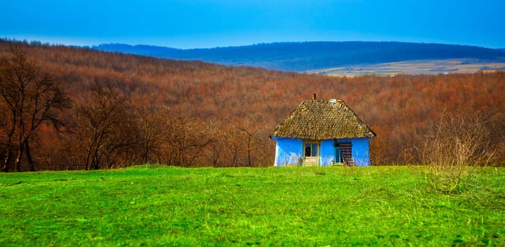 Abandoned blue old cottage during spring time in Romania.