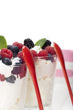 Yoghurt mousse dessert with colourful berries and mint leaves