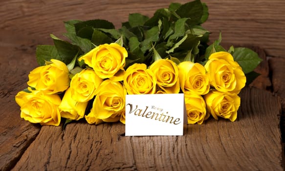 Yellow roses on a wooden background and a card "Be my Valentine"""