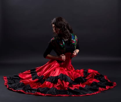 Young woman stretches back in spanish traditional clothes