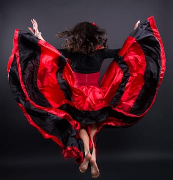 Young romany woman fly in spanish traditional clothes