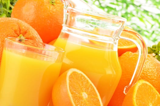 Glass and jug of orange juice and fruits