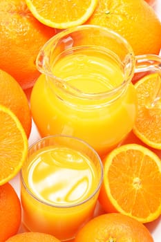 Glass and jug of orange juice and fruits