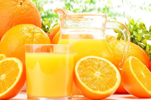 Glass and jug of orange juice and fruits