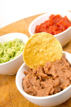 Food Appetizers Chips and Salsa Refried Beans Guacamole on Wood Cutting Board
