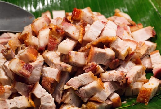 Roast pork cut into pieces on palm leaf in Thailand