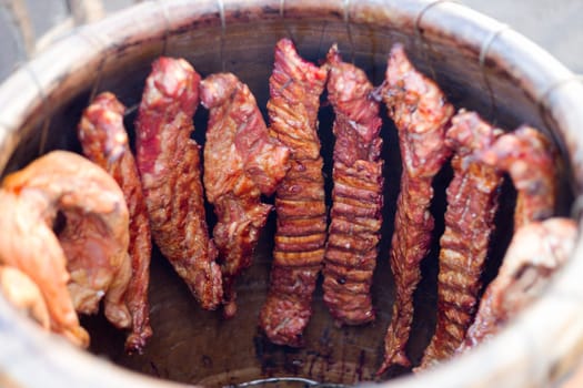 Grilled smoked pork ribs and chicken. Cooked in a clay barrel in Thailand market.