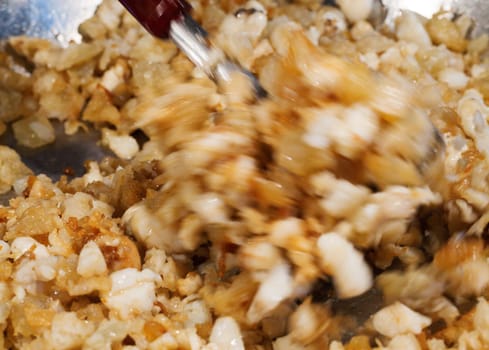 Fried cracklings actively mixed in a pan