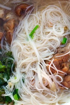 Thai soup with noodles and meat close up