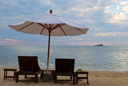 Two beds and an umbrella on the beach at sunset. Koh Chang, Thailand.