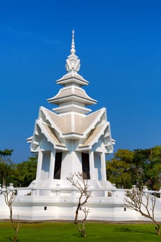 spire of the White Temple in Chiang Mai, Thailand, on a background of blue sky