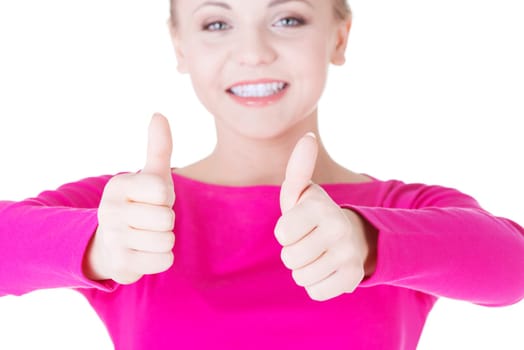 Young casual woman gesturing thumbs up. Isolated on white
