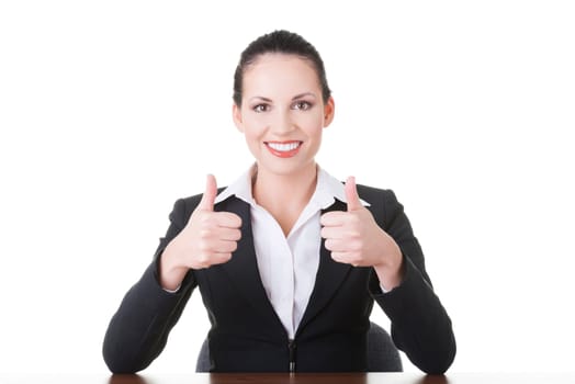Young woman at the desk gesturing OK , isolated on white