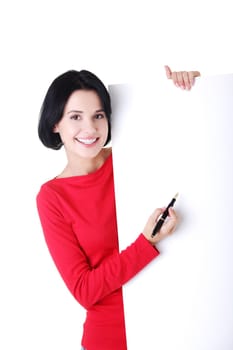 Happy beautiful woman writing with a pen on blank board. Student or businesswoman.
