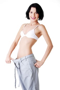 Young fit woman showing how much weight did she lost. Isolated on white