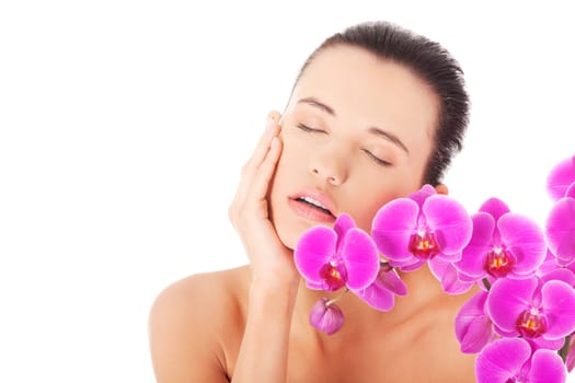 Portrait of beautiful young woman with health skin and with orchid flower. Spa concept.