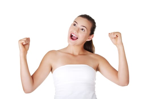 Excited teen woman with fists up, isolated on white background