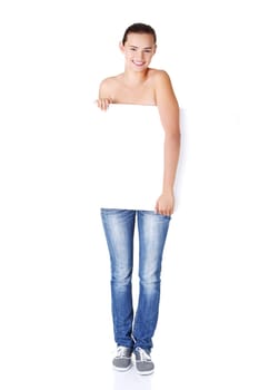 Beautiful teen girl behind big blank billboard, isolated on white background