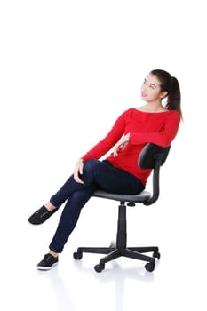 Young happy woman sitting on a wheel chair, isolated over a white background
