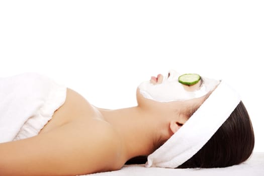 Young woman with cucumber slices on the face in a spa saloon