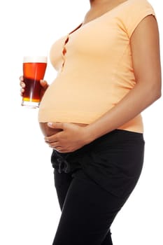 Pregnant woman holding a glass of alcohol next to her tummy, isolated on white background.