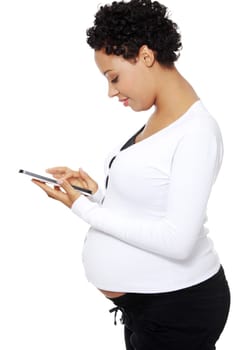 Pregnant woman relaxing with a computer tablet , isolated on white