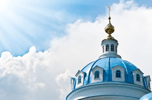 Blue dome of beautiful old russian church with cloudy sky in background