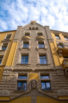 beautiful yellow old house with blue cloudy sky in background (Riga, Latvia, Europe)