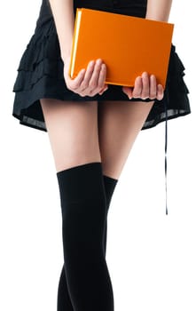 view of the lower body part isolated on white background of woman wearing skirt, stockings holding book in her hands
