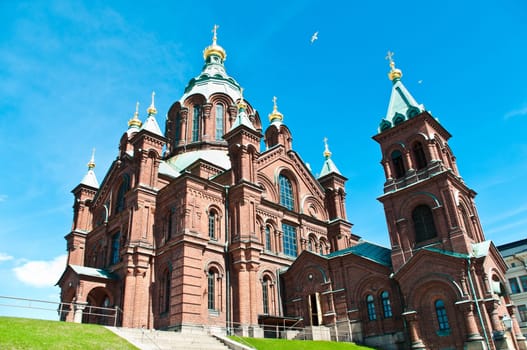 view of Uspenski Orthodox Church with blue sky in background in Helsinki, Finland, Europe