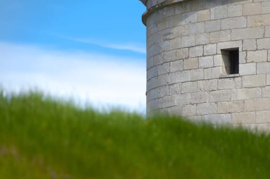Kuressaare castle tower with blue sky in background and green grass in foreground (Saarema, Estonia)