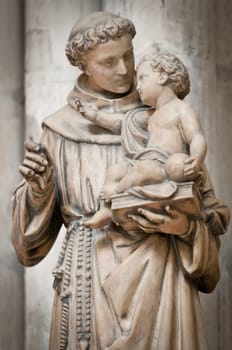 Statue of man holding small boy on his hands. Sculpture from Saint Denis cathedral. Paris, France, Europe.