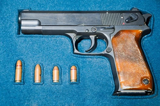 pistol and four bullets in blue box