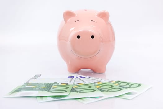 Piggy bank with euro bills isolated on white background