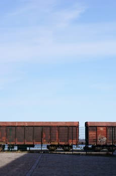 Die Seitenansicht von Eisenbahnwaggons hinter einem Zaun.
