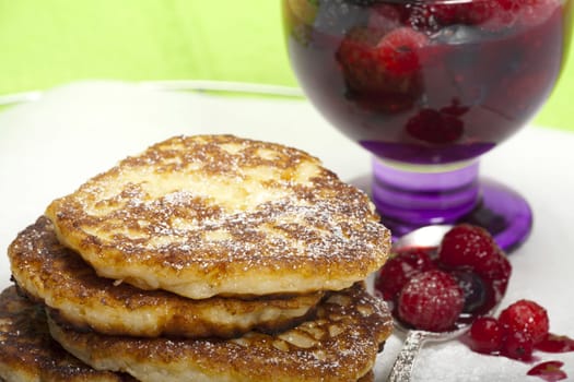 Homemade rice pudding pancakes with powdered sugar and fruity berry groats according to a traditional recipe