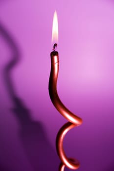 burning candle on colourful vivid background