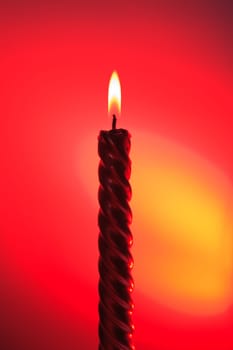 red burning candle on colourful vivid background