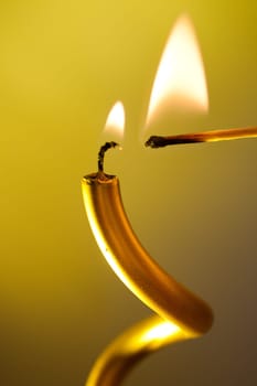 burning candle and match on colourful vivid background